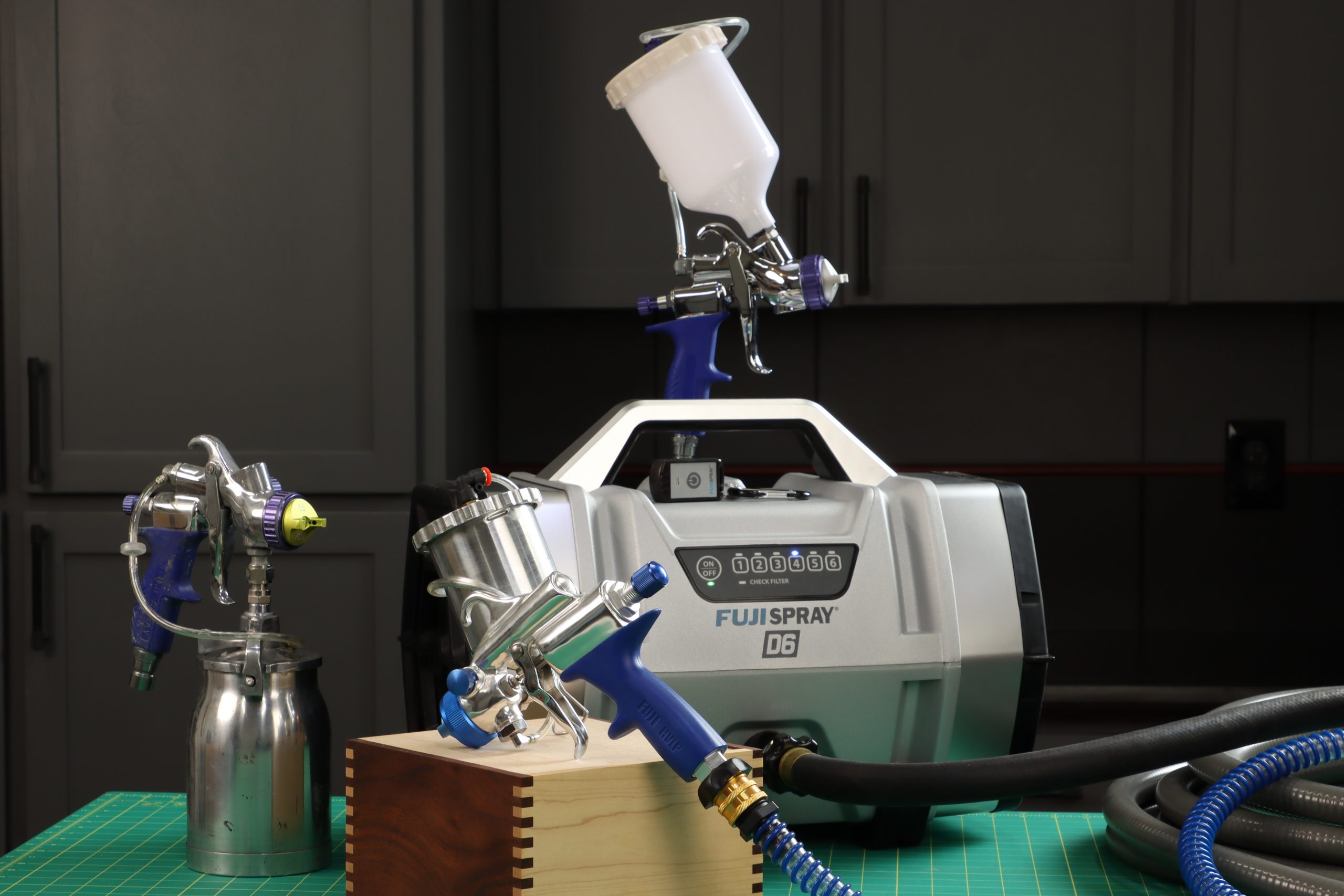 a T70 bottom feed, G-XPC compact gravity feed, and T75G midsize gravity feed spray gun with D6